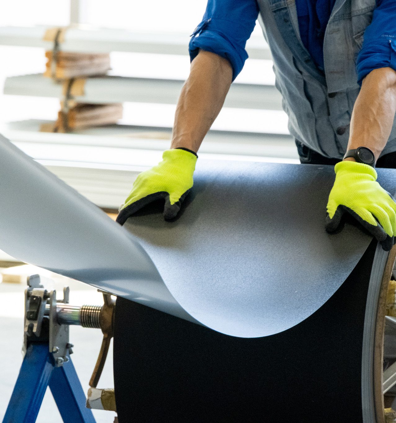 Worker handling a custom-fabricated sheet metal panel in the NeoTech manufacturing shop