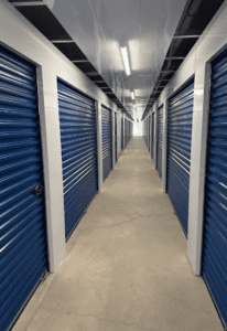 Hallway locker system with corrugated corridor panels in a self-storage facility