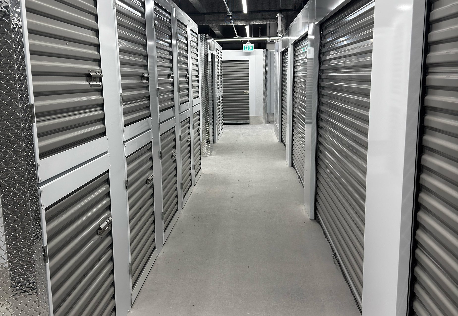 Completed self-storage corridor with grey corrugated locker doors
