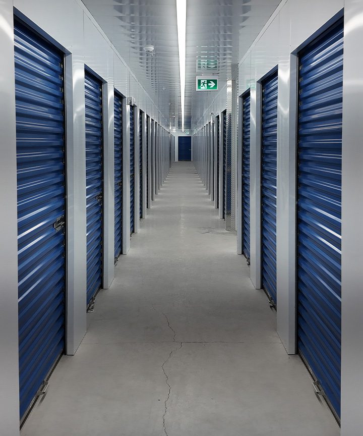 Self-storage corridor with blue roll-up doors manufactured by NeoTech